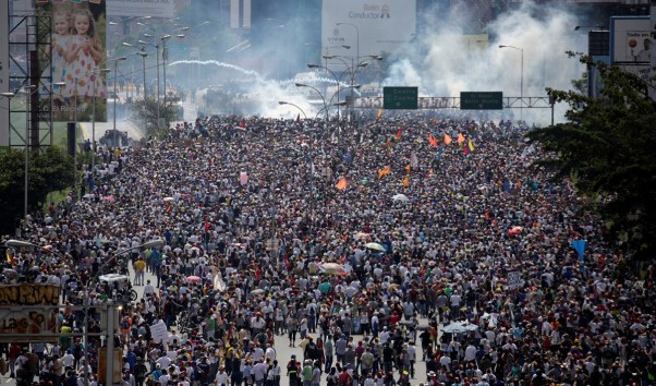 Opposition supporters clash with riot security forces while rallying against President Nicolas Maduro in Caracas